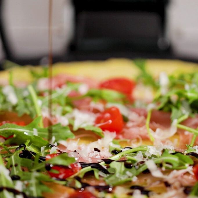 Arugula and Proscuitto Crepe with balsamic being drizzled